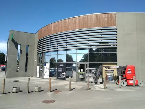 Façade vitrée de l'Intermarché d'Arradon traitée au film solaire Chrome 270 XC, pose réalisée à la nacelle