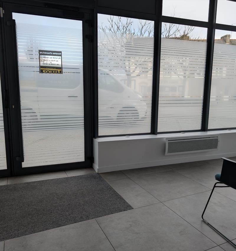 Salle d'attente du centre Entendre d'Auray vue de l'intérieur, lumière conservée derrière les bandes dépolies